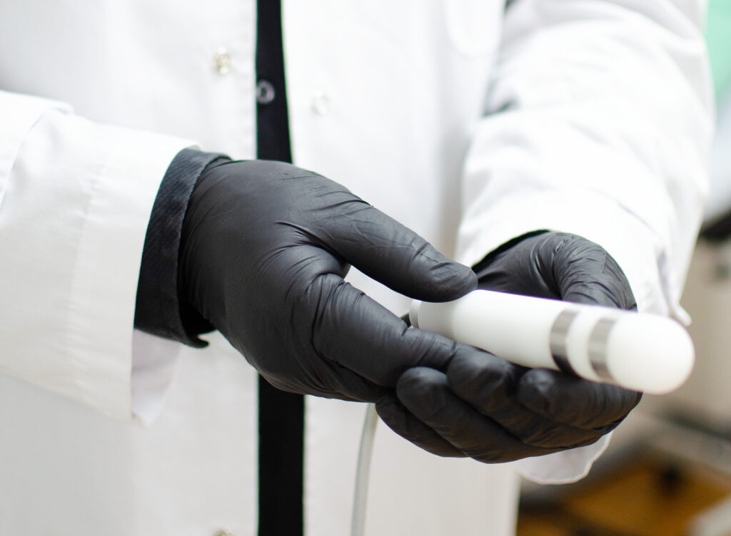 Manos de médico con electro estimulador del canal vaginal